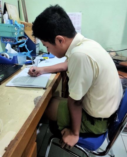 niko mengerjakan tugas di rumah